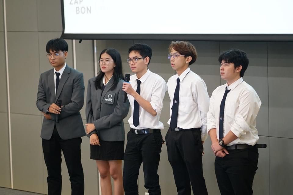 InnoEM student team presenting on stage in program uniform